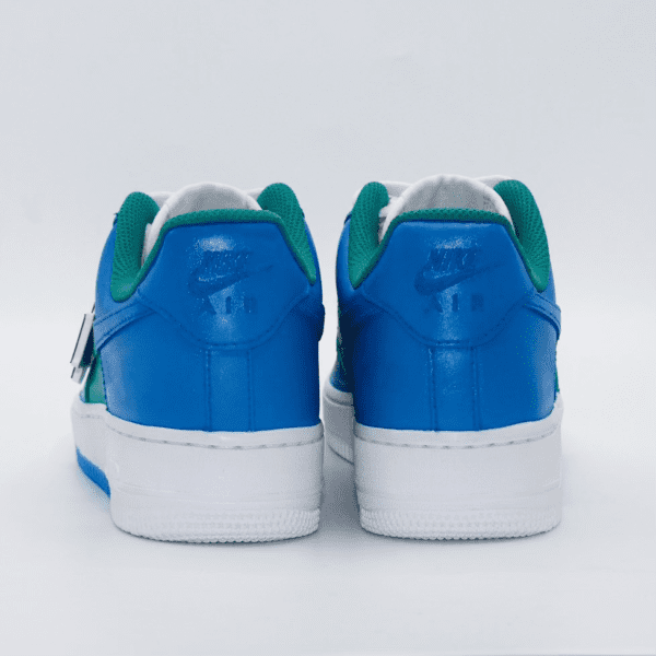 A pair of blue and green sneakers on a white surface.